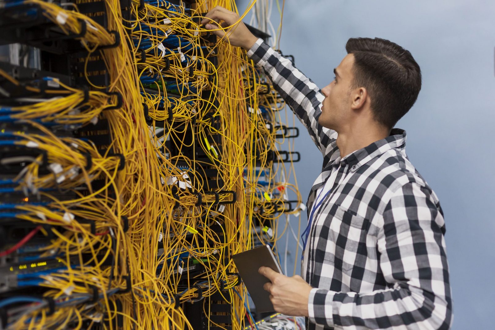 Network engineer tracing cables on a busy server rack